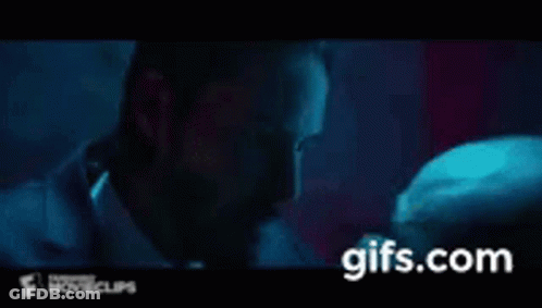 A Man In A Suit And Tie Is Kissing Another Man On The Cheek . GIF