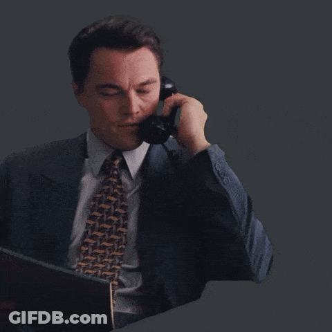 A Man In A Suit And Tie Is Laughing And Clapping His Hands GIF