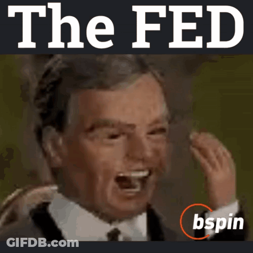 A Man In A Suit And Tie Is Laughing In Front Of The Fed Logo GIF