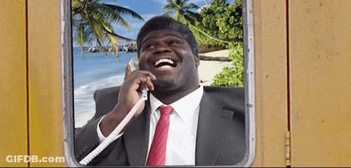 A Man In A Suit And Tie Is Laughing While Talking On The Phone GIF