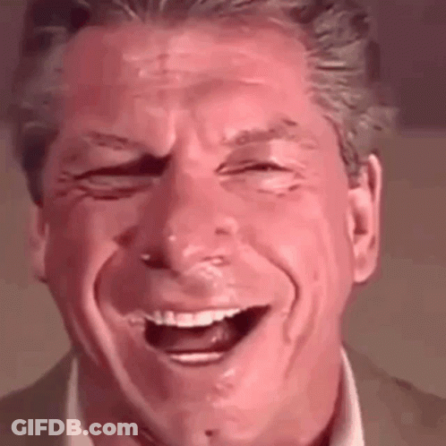 A Man In A Suit And Tie Is Laughing With His Eyes Closed . GIF