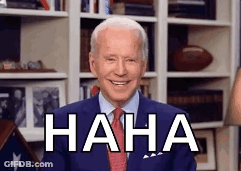 A Man In A Suit And Tie Is Laughing With The Word Haha Behind Him GIF