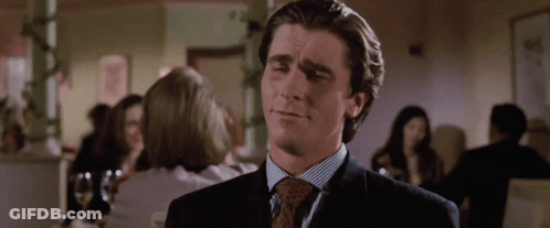 A Man In A Suit And Tie Is Looking At Something GIF