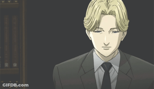 A Man In A Suit And Tie Is Looking At The Camera GIF