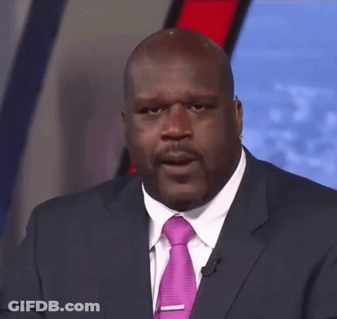 A Man In A Suit And Tie Is Looking At The Camera . GIF