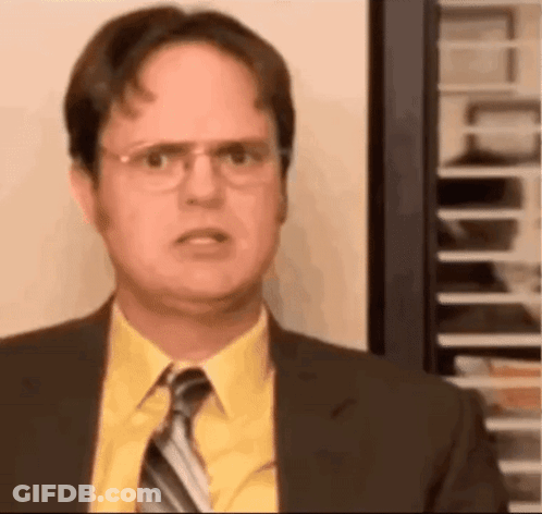 A Man In A Suit And Tie Is Looking At The Camera . GIF
