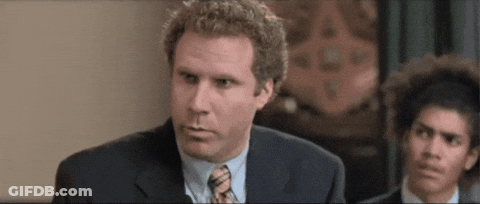 A Man In A Suit And Tie Is Looking At The Camera While Another Man Looks On . GIF