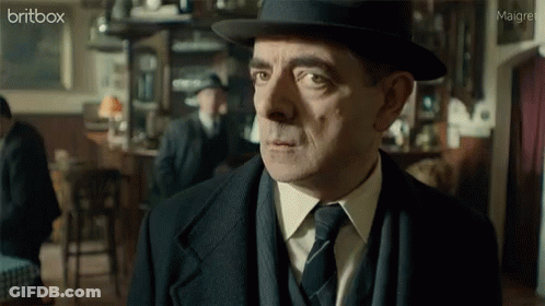 A Man In A Suit And Tie Is Looking At The Camera With A Britbox Logo In The Corner GIF