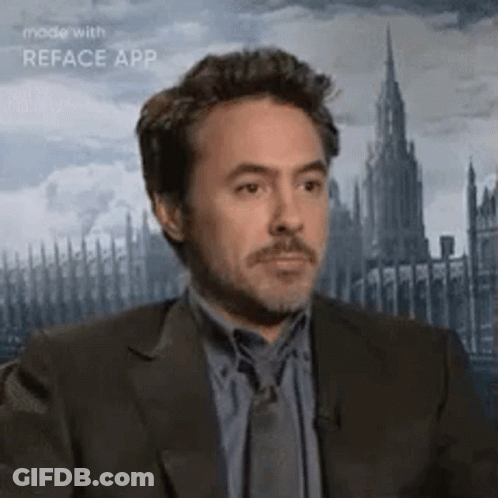 A Man In A Suit And Tie Is Looking At The Camera With A Castle In The Background . GIF