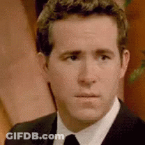 A Man In A Suit And Tie Is Looking At The Camera With A Serious Look On His Face . GIF