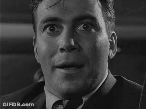 A Man In A Suit And Tie Is Looking At The Camera With His Mouth Open GIF