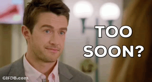 A Man In A Suit And Tie Is Looking At The Camera With The Words Too Soon Behind Him GIF