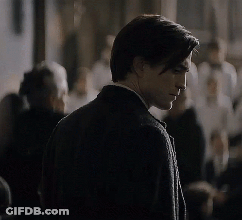 A Man In A Suit And Tie Is Looking Down GIF