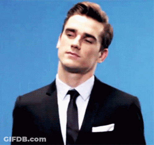 A Man In A Suit And Tie Is Looking Down GIF