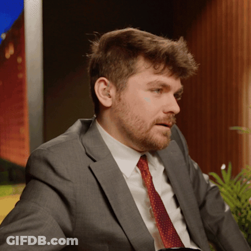 A Man In A Suit And Tie Is Looking To The Side GIF