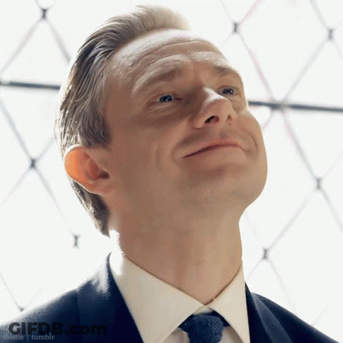 A Man In A Suit And Tie Is Looking Up At The Sky GIF