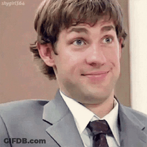 A Man In A Suit And Tie Is Making A Face . GIF