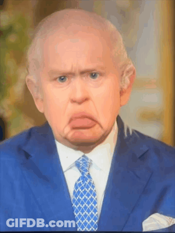 A Man In A Suit And Tie Is Making A Face GIF