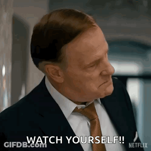 A Man In A Suit And Tie Is Making A Face And Saying `` Watch Yourself '' . GIF
