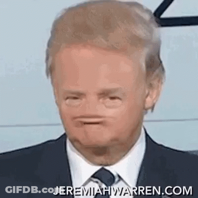 A Man In A Suit And Tie Is Making A Face . GIF