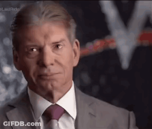 A Man In A Suit And Tie Is Making A Face . GIF