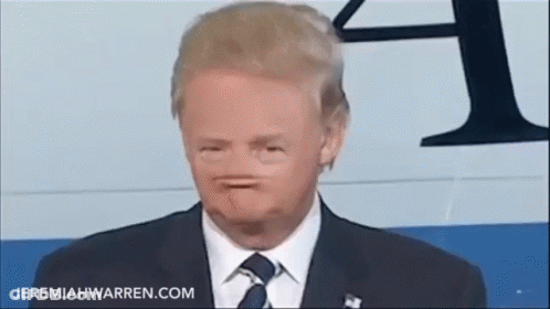 A Man In A Suit And Tie Is Making A Face . GIF