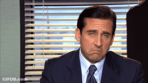 A Man In A Suit And Tie Is Making A Face GIF