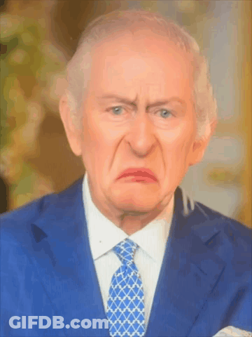 A Man In A Suit And Tie Is Making A Face GIF