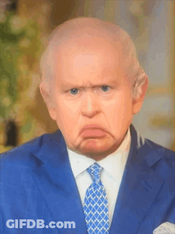 A Man In A Suit And Tie Is Making A Face GIF