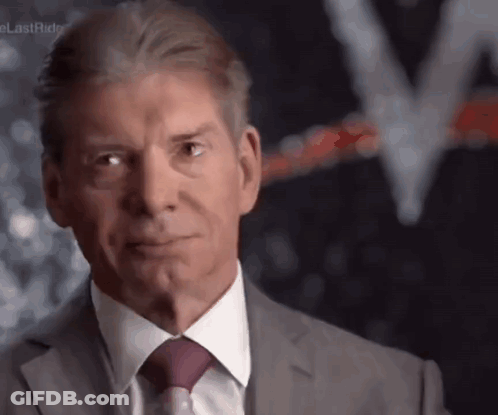 A Man In A Suit And Tie Is Making A Funny Face GIF