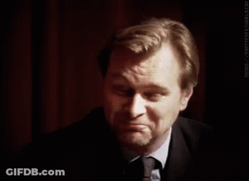 A Man In A Suit And Tie Is Making A Funny Face . GIF