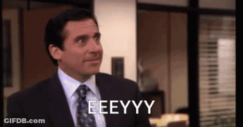 A Man In A Suit And Tie Is Making A Funny Face And Saying Eeeyyy . GIF
