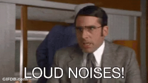 A Man In A Suit And Tie Is Making A Funny Face And Saying `` Loud Noises '' . GIF