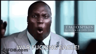 A Man In A Suit And Tie Is Making A Funny Face And Saying War Fucking Eagle . GIF