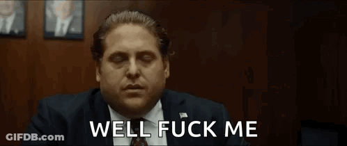 A Man In A Suit And Tie Is Making A Funny Face And Saying Well Fuck Me . GIF
