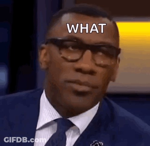 A Man In A Suit And Tie Is Making A Funny Face And Says What . GIF