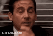 A Man In A Suit And Tie Is Making A Funny Face . GIF