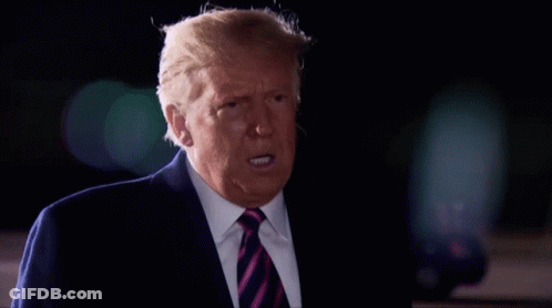 A Man In A Suit And Tie Is Making A Funny Face GIF
