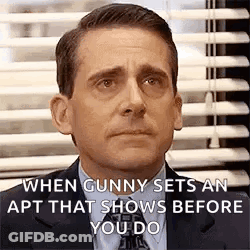 A Man In A Suit And Tie Is Making A Funny Face In Front Of A Window With Blinds . GIF