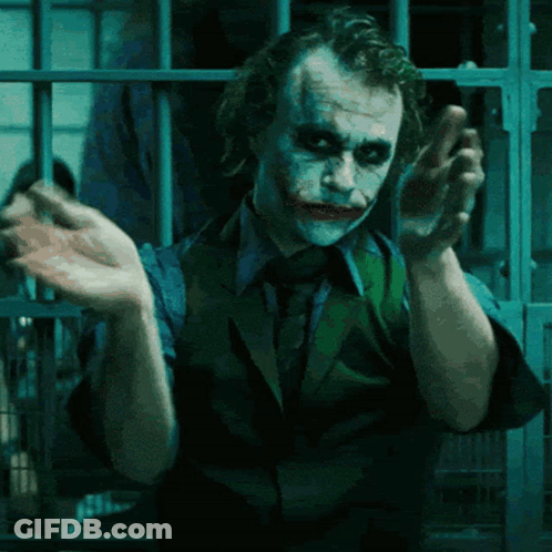 A Man In A Suit And Tie Is Making A Funny Face GIF