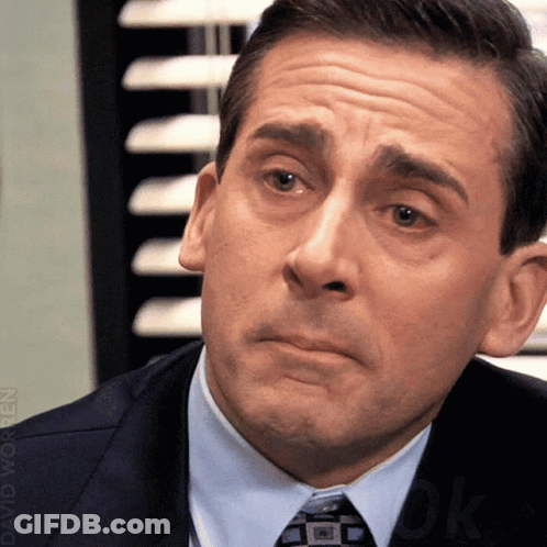 A Man In A Suit And Tie Is Making A Funny Face GIF