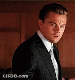 A Man In A Suit And Tie Is Making A Funny Face GIF