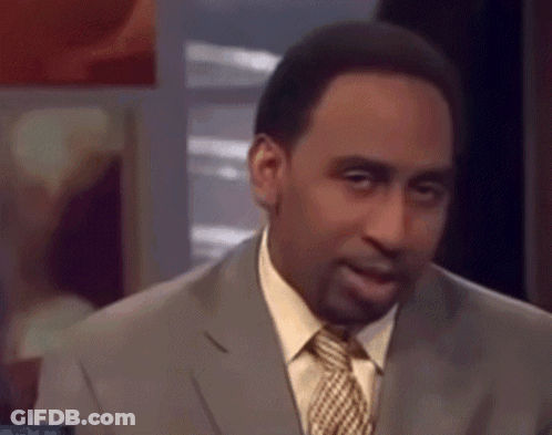 A Man In A Suit And Tie Is Making A Funny Face . GIF