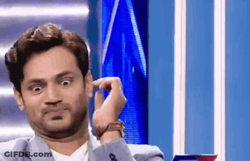 A Man In A Suit And Tie Is Making A Funny Face GIF