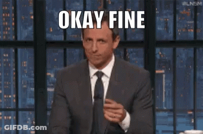A Man In A Suit And Tie Is Making A Funny Face While Giving A Thumbs Up . GIF