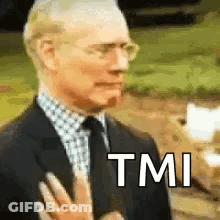 A Man In A Suit And Tie Is Making A Funny Face While Holding His Hand To His Chest . GIF