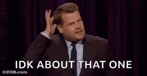 A Man In A Suit And Tie Is Making A Funny Face While Talking On A Stage . GIF