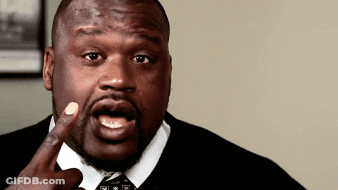 A Man In A Suit And Tie Is Making A Funny Face With His Finger In His Mouth GIF