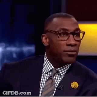 A Man In A Suit And Tie Is Making A Funny Face With His Mouth Open . GIF
