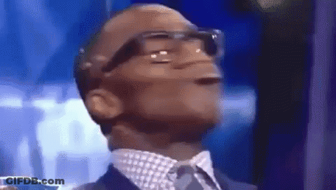 A Man In A Suit And Tie Is Making A Funny Face With His Mouth Open . GIF